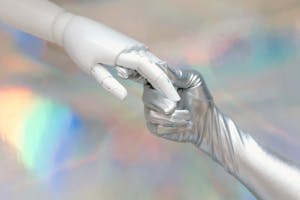 Close-up of a robot hand and silver-gloved hand touching, symbolizing human-robot connection. Close-up of a robot hand and silver-gloved hand touching, symbolizing human-robot connection.