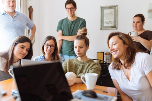 A diverse group of adults at work, enjoying a casual meeting indoors with focus and smiles. A diverse group of adults at work, enjoying a casual meeting indoors with focus and smiles.