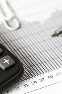 Close-up of a calculator and pen on a bar graph, representing finance and accounting. Close-up of a calculator and pen on a bar graph, representing finance and accounting.